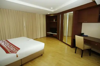 a bedroom with a bed and a desk and a chair at The Ninth Place Serviced Residence in Bangna
