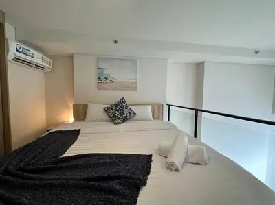 a bedroom with a white bed with a black blanket at S87-7052 BTS Onnut High Floor Gym Swim Good View in Bangkok