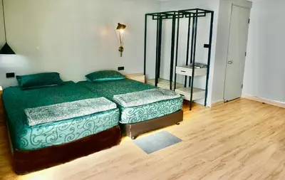a bedroom with a green bed and a mirror at Hash Apartment Silom Soi 3 - hip and funky with rooftop view in Bangkok
