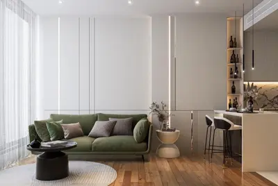 a living room with a green couch and a kitchen at The Address 28 in Bangkok