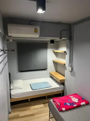 a small room with a small bed in a trailer at Bangkok Chat box Hostel in Bangkok