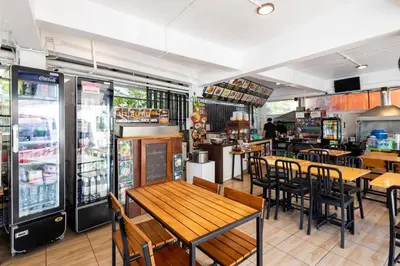 a restaurant with tables and chairs and a refrigerator at Nature Boutique Residence in Bangkok