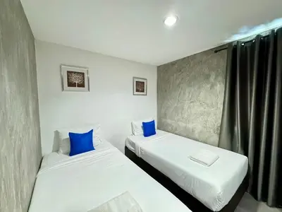 two beds in a room with blue pillows at Nature Boutique Residence in Bangkok