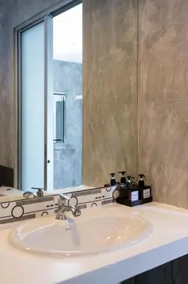 a bathroom with a sink and a large mirror at Nature Boutique Residence in Bangkok