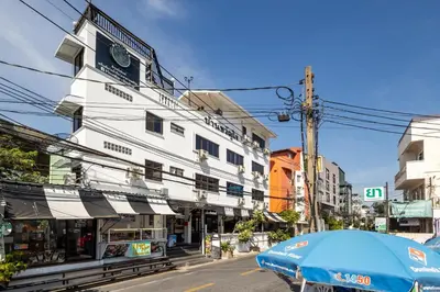 a white building with an umbrella on a street at Nature Boutique Residence in Bangkok