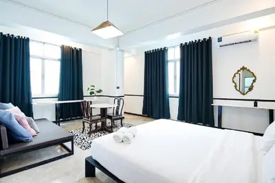 a bedroom with a white bed and a table and chairs at The Character China Town เดอะ คาแรคเตอร์ เยาวราช Mrt วัดมังกร Pro in Khlong San