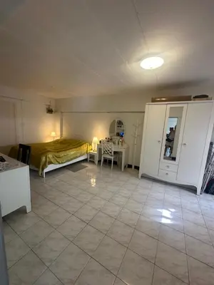 a bedroom with a bed and a table in a room at Mahasap Ramindhra next to MRT Station in Bang Khen