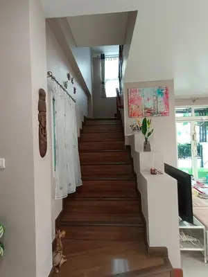 a staircase in a house with white walls and wooden floors at Be Cute#บ้านพักเหมาหลัง 6 ท่าน เด็ก0-7ขวบพักฟรี 2 ท่าน in Ban Khung Taphao