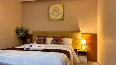 a bedroom with a large white bed with pillows at Sam Homestay in Bangkok