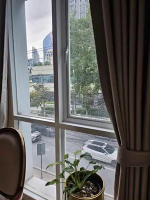 a window with a potted plant and a view of a street at Sam Homestay in Bangkok