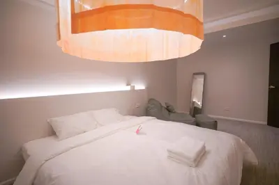 a bedroom with a large bed with two white towels on it at ABC Bangkok RCA in Bangkok