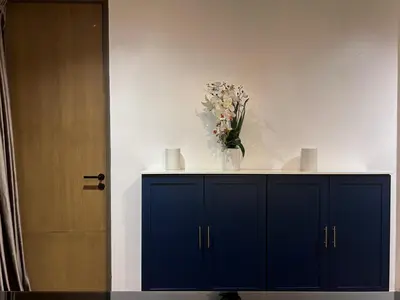 a blue cabinet with a vase of flowers on it at Brown Brick Thonglor - Blue Blueberry Room in Khlong Toei