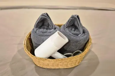 a basket filled with gray towels and a remote control at Townhouse at Yaek Lam Sali station for 6 pax in Ban Bang Toei (1)