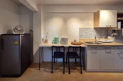 a kitchen with a counter with two chairs and a refrigerator at Townhouse at Yaek Lam Sali station for 6 pax in Ban Bang Toei (1)