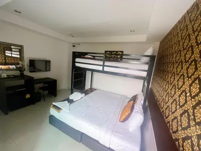 a bedroom with two bunk beds and a desk at Adamaz House in Bangkok