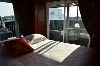 a bed in front of a window with a view at Adamaz House in Bangkok