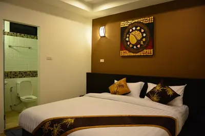 a bedroom with a bed and a clock on the wall at Adamaz House in Bangkok