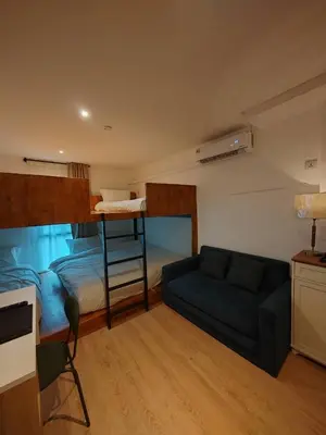 a living room with a bunk bed and a couch at The Motuga Hostel Bangkok in Bangkok
