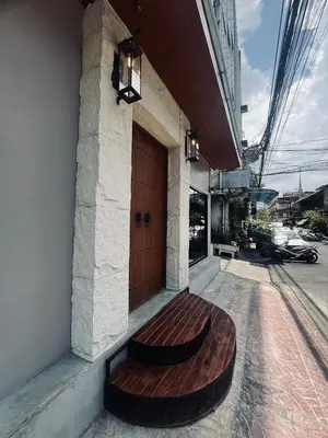 a wooden bench sitting on the side of a building at The Motuga Hostel Bangkok in Bangkok