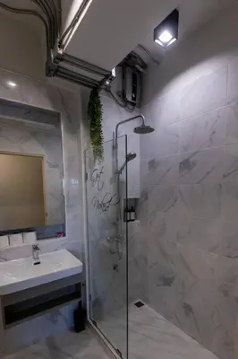 a bathroom with a shower and a sink at Cozy 2BR Duplex-Apartment in Thong Lor in Bangkok