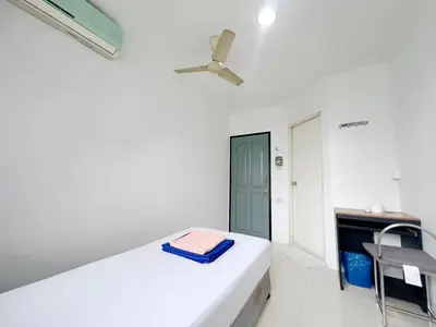 a white room with a bed with a blue towel on it at V Reserve at Merry V in Bangkok