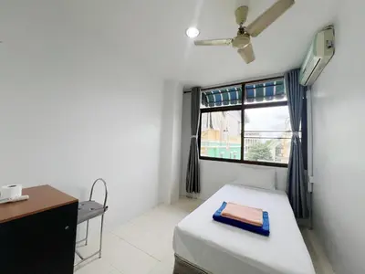 a small bedroom with a bed and a window at V Reserve at Merry V in Bangkok