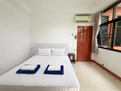 a bedroom with a white bed with blue pillows on it at V Reserve at Merry V in Bangkok