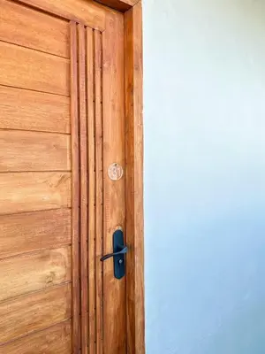 a wooden door with a black door knocker on it at Megun 10 in Ban Bang Phlat