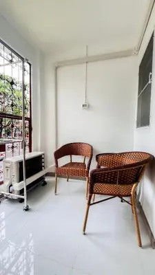 two chairs and a table in a room with a window at uouRangnamHouse in Bangkok