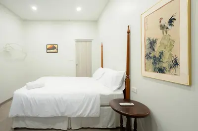 a white bedroom with a bed and a table at XX HD China Town MRT Dragon Temple in Samphanthawong
