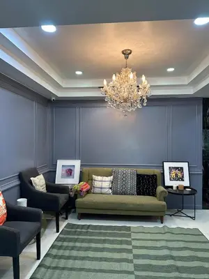 a living room with a couch and chairs and a chandelier at Homemii 59 in Ban Chuat Plai Mai