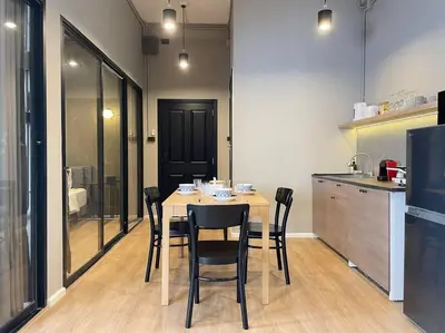 a dining room with a table and chairs in a kitchen at Vélin Khaosan - 5th Floor apartment with 2Bedrooms in Bangkok