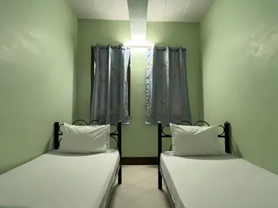 two beds sitting in a room with curtains at Bella Bella House in Bangkok