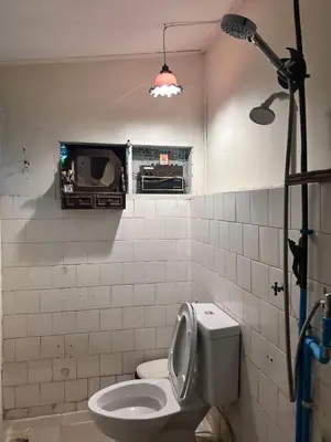 a bathroom with a white toilet and a window at Chest's Place in Bangkok