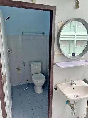 a bathroom with a toilet and a mirror and a sink at KPP Mansion in Amphoe Phra Khanong