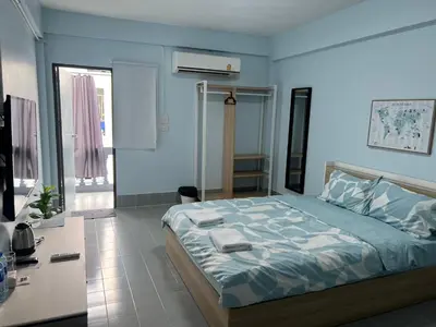 a bedroom with a bed and a desk in it at KPP Mansion in Amphoe Phra Khanong