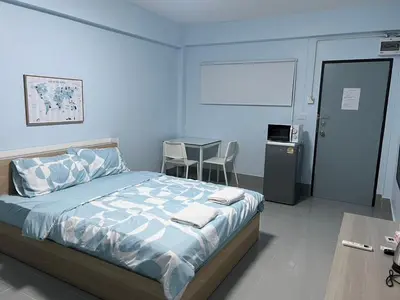 a bedroom with a bed and a table in it at KPP Mansion in Amphoe Phra Khanong