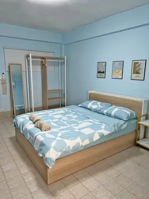 a bedroom with a large bed with blue walls at KPP Mansion in Amphoe Phra Khanong