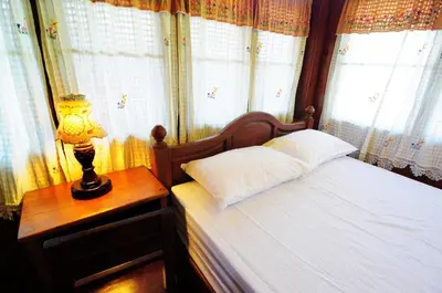 a bedroom with a bed and a lamp on a table at Kaloang home in Bangkok