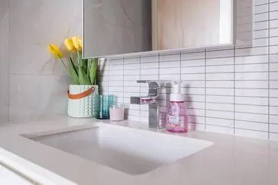 a bathroom counter with a sink and a vase of flowers at 2 BR Suite at BTS NANA Sukhumvit 11 Floor 15 Pool not permitted in Bangkok