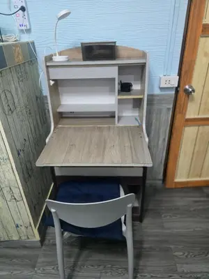 a desk with a chair under a table with a drawer at 204 Olan Place Spacious Studio with Wi-fi near BTS Skytrain in Bangkok