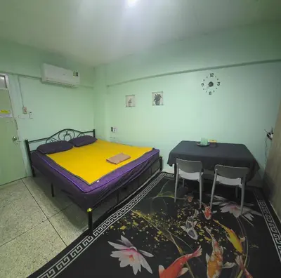 a room with two beds and a table and two chairs at Spacious Studio with Private kitchen near Skytrain in Bangkok