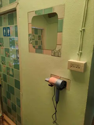 a hair dryer plugged into a wall in a bathroom at Spacious Studio with Private kitchen near Skytrain in Bangkok