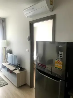 a kitchen with a refrigerator and a table with a television at Owow o2 in Bang Chak