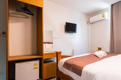 a bedroom with a bed and a desk and a tv at XX GO INN Khaosan Road BKK โกอินน์ ตรอกข้าวสาร in Bangkok