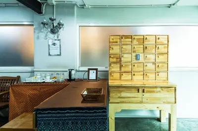 a room with a table and a wooden cabinet at XX GO INN Khaosan Road BKK โกอินน์ ตรอกข้าวสาร in Bangkok