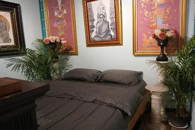 a bed in a room with pictures on the wall at 64 Sweet Home Dusit BKK in Bangkok