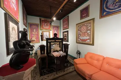 a living room with a couch and paintings on the walls at 64 Sweet Home Dusit BKK in Bangkok