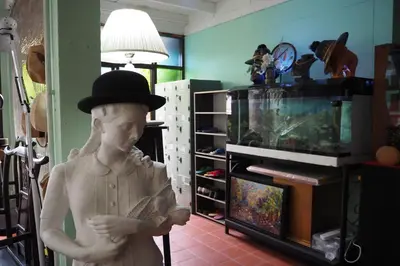 a statue of a boy wearing a hat and a fish tank at 64 Sweet Home Dusit BKK in Bangkok