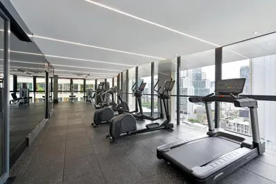 a gym with cardio equipment in a building at GM Estate Hotel and Executive Apartments, Bangkok Sukhumvit 20 in Bangkok